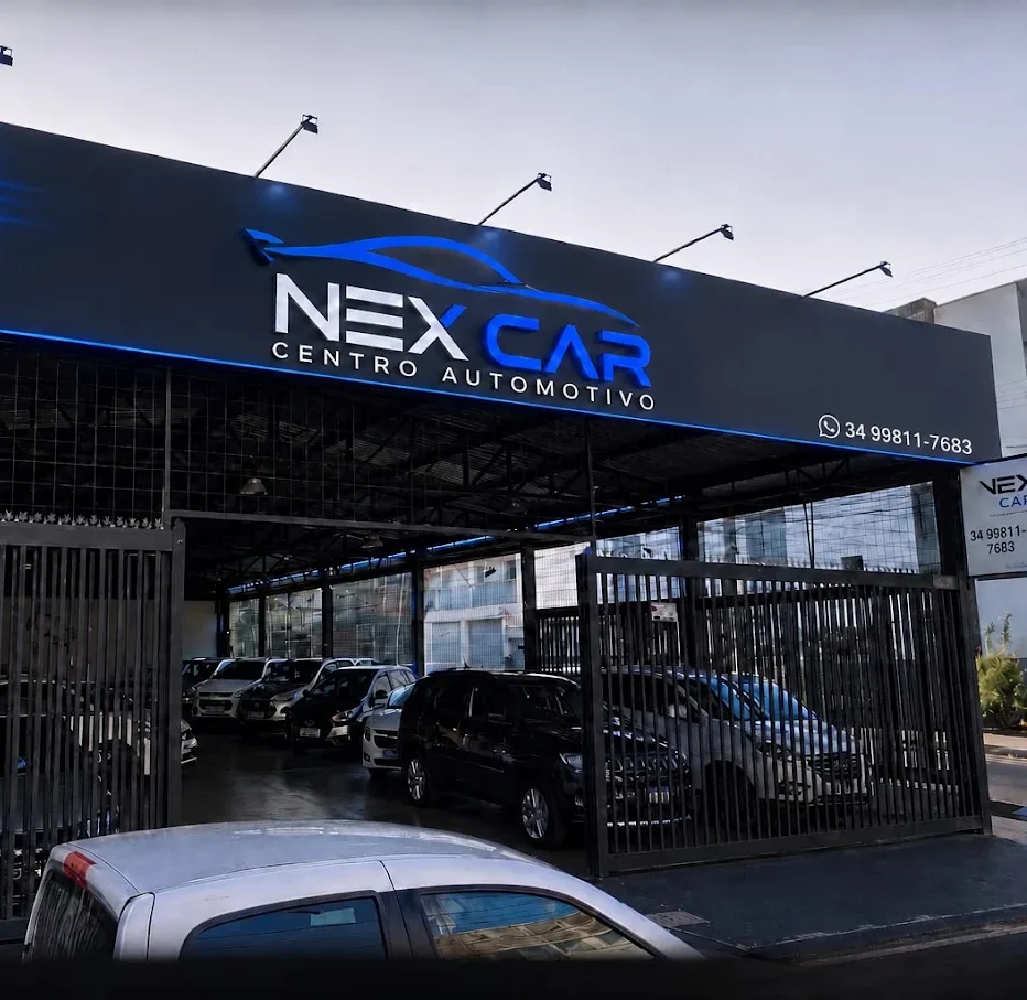 Fachada da NexCar Centro Automotivo na Av. Brasil, 3395, em Uberlândia, com o letreiro iluminado